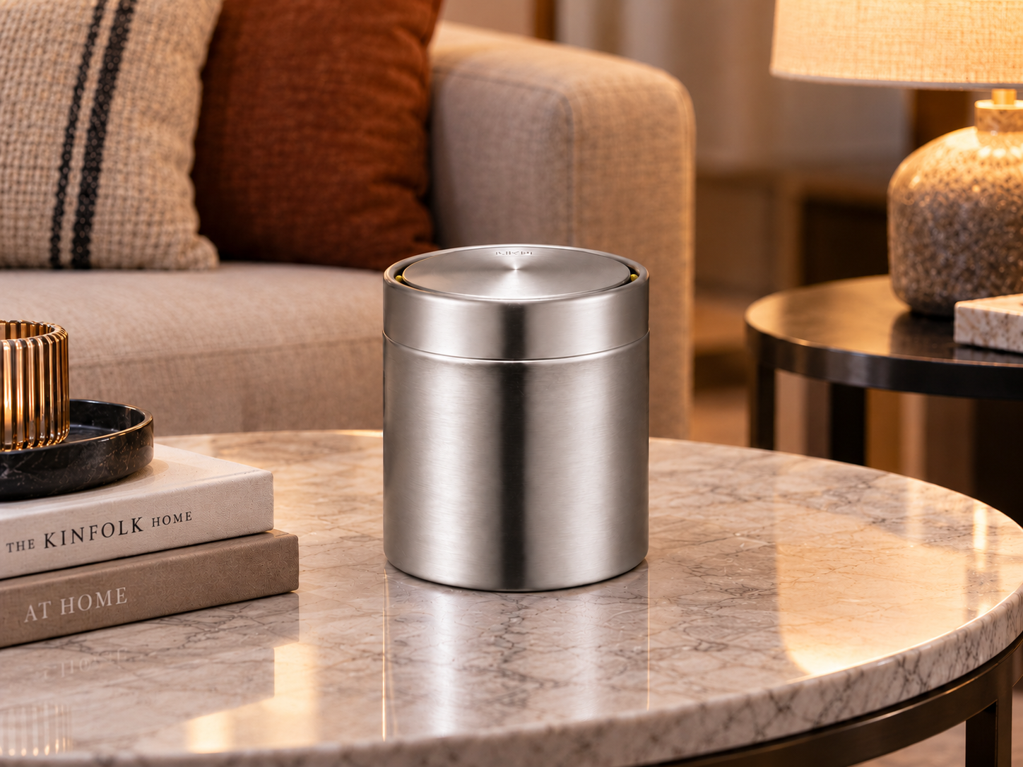 EKO Fandy Table Bin – Elegant Living Room Accessory EKO Fandy 1.5L mini dustbin on a black marble living-room side table beside a neutral sofa and decorative lamp.